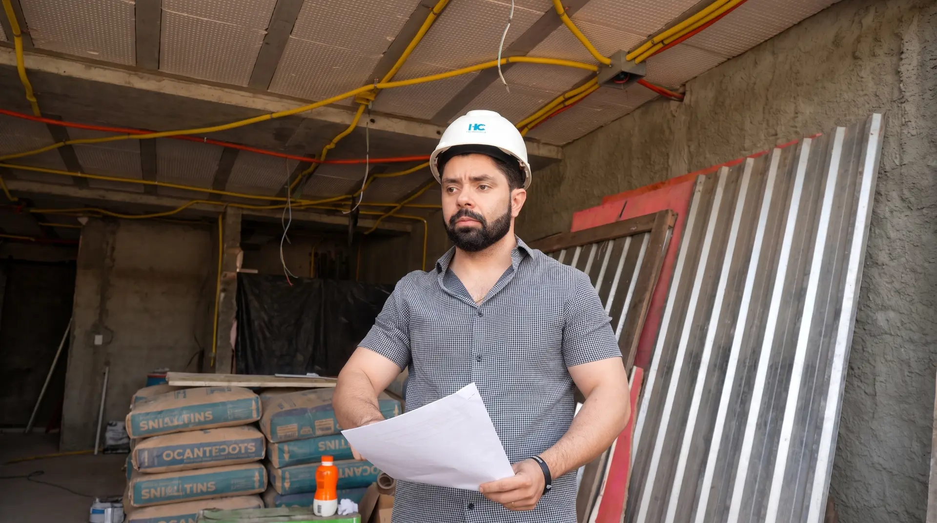 Engenheiro da HC Engenharia analisando documentos técnicos em canteiro de obras em Goiânia