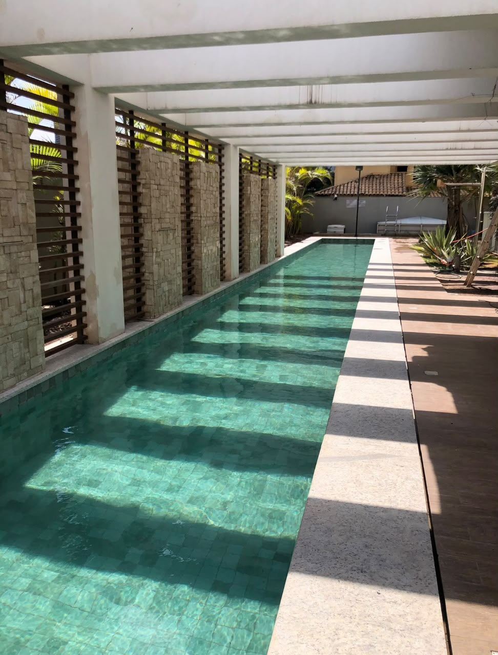 Detalhe de piscina e pergolado de concreto em residência em Goiânia